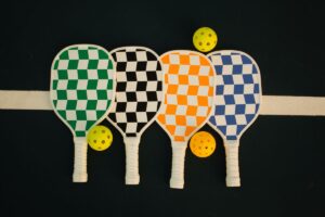 Palas de pickleball con gorras y accesorios sobre la pista
