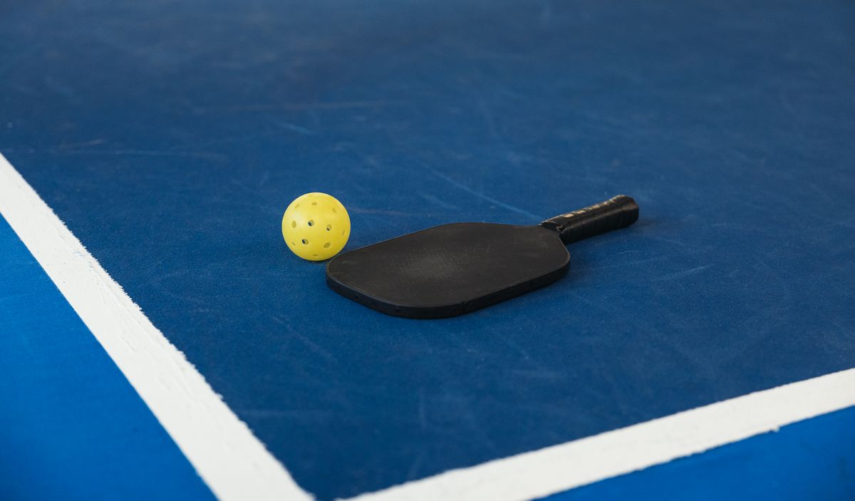 Palas y pelota de pickleball junto a zapatillas deportivas