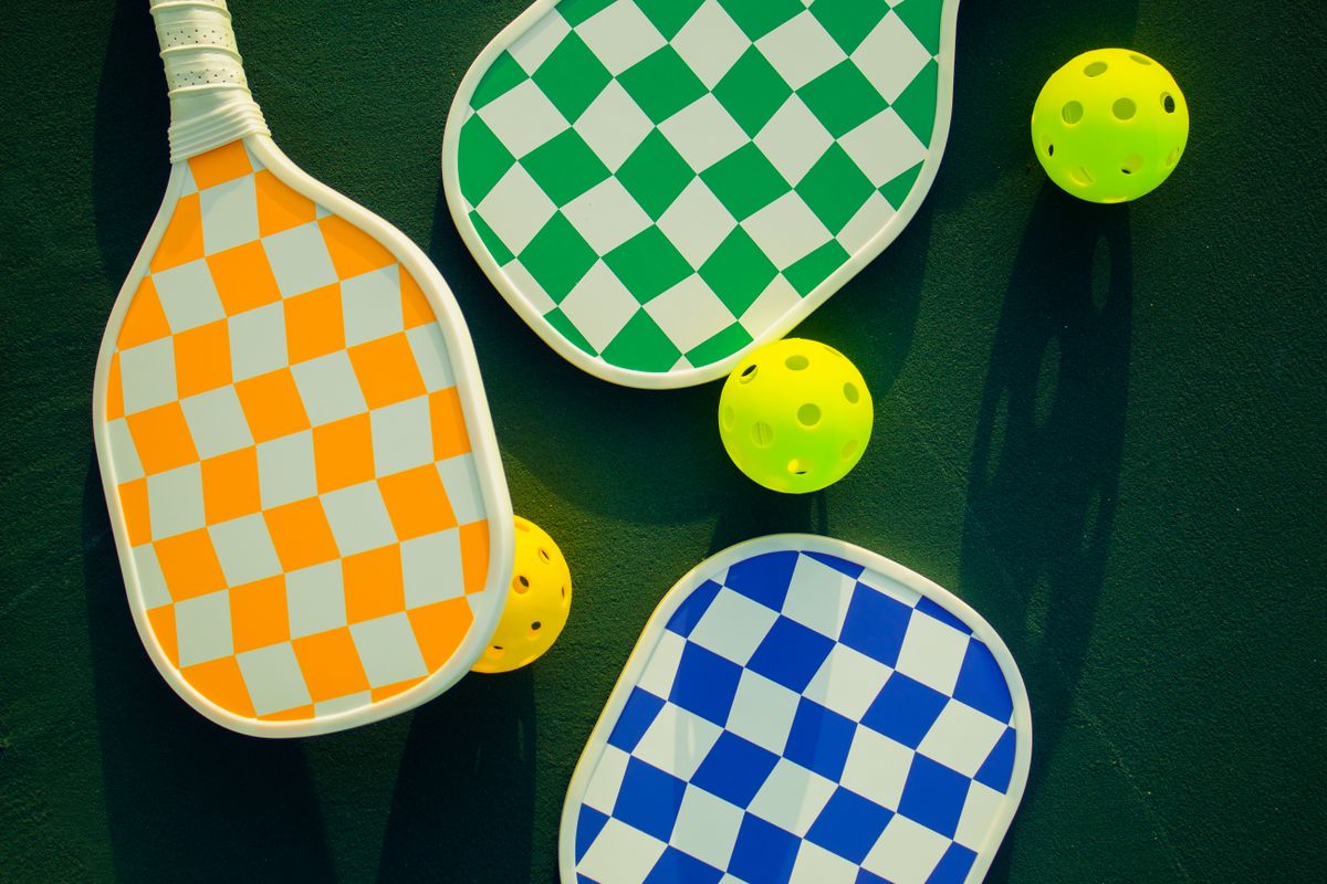 Palas y pelotas de pickleball en una pista soleada