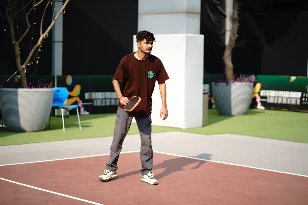 Hombre con ropa deportiva en movimiento durante un partido de pickleball