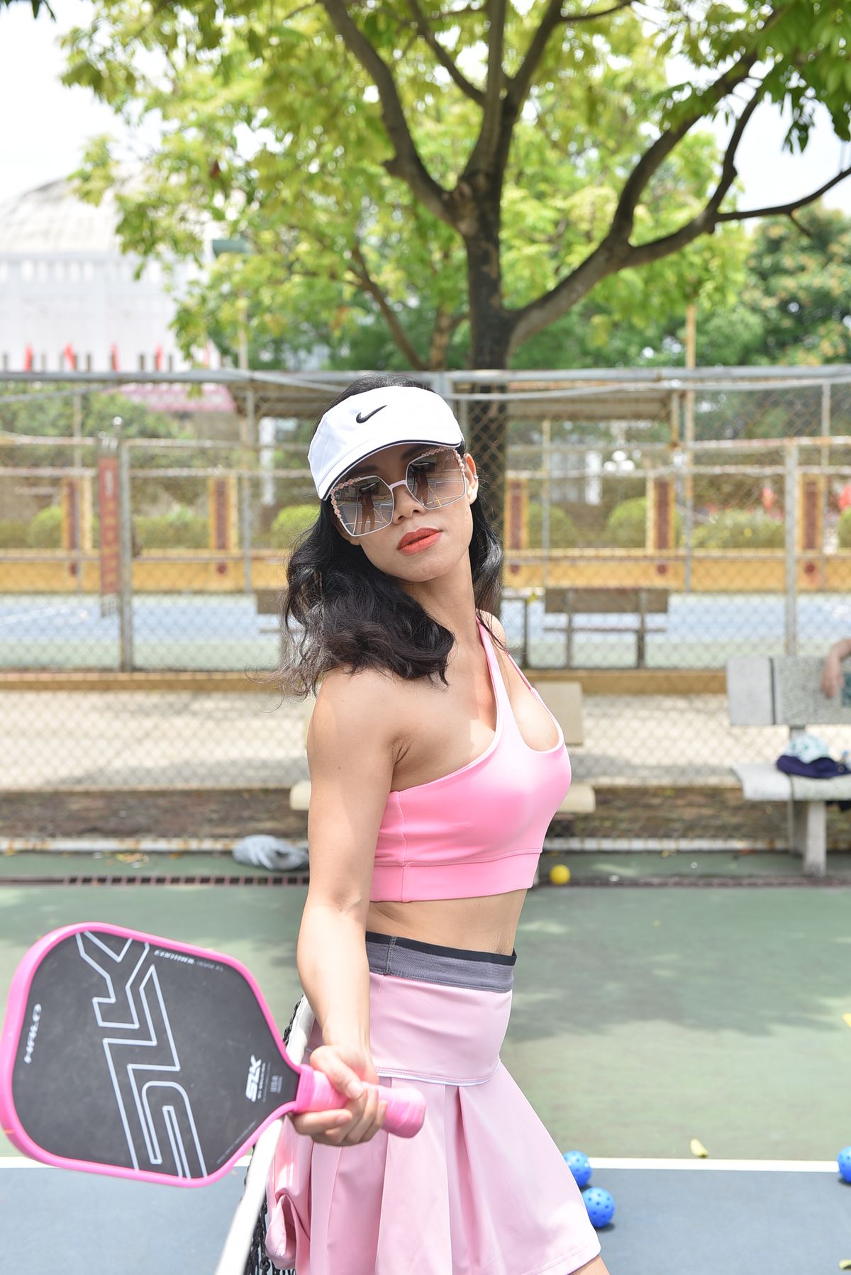 Mujer con ropa deportiva jugando a pickleball al aire libre